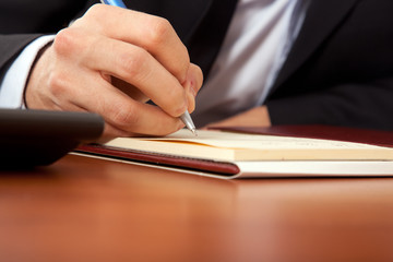Businessman writing on the agenda in his office