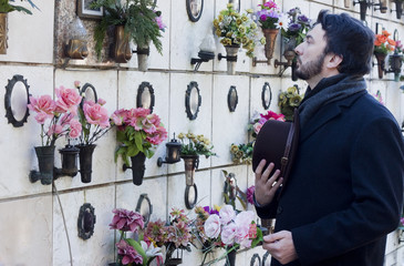 Mourning Man Standing on a Grave at the Cemetery