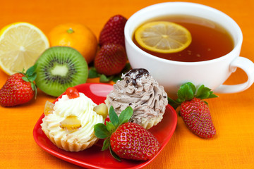 lemon,lemon tea,mandarin,kiwi,cake and strawberries lying on the