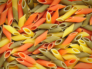 Multicolored pasta of red, yellow and green color, organic square background