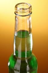 Bottle with a green drink on the yellow-brown background