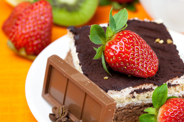 lemon tea,chocolate, kiwi,cake and strawberries lying on the ora