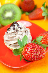 lemon,mandarin,kiwi,cake and strawberries lying on the orange fa