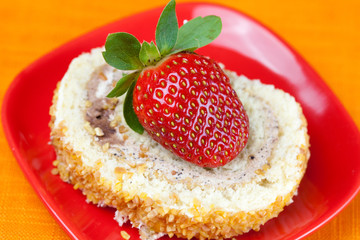 cake and strawberries lying on the orange fabric