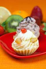 lemon,mandarin,kiwi,cake and strawberries lying on the orange fa