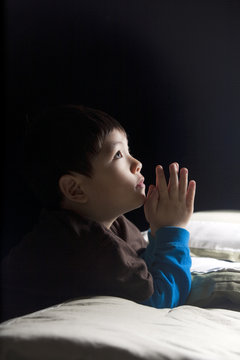 Boy saying his prayers.