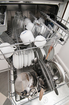 Dish washer with dirty dishes and kitchenware