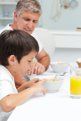 Obraz na płótnie Canvas Father having his breakfast with his son