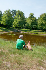 Naklejka na ściany i meble Man with his dog near the water