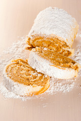 Sugary swiss roll cake studio macro at wooden background. Shallo