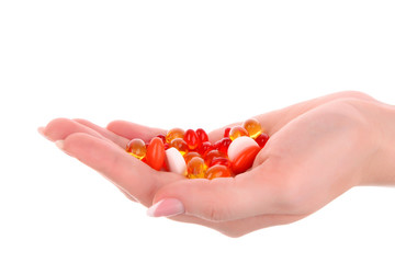 red and yellow  capsules of vitamins on the hand on a white back