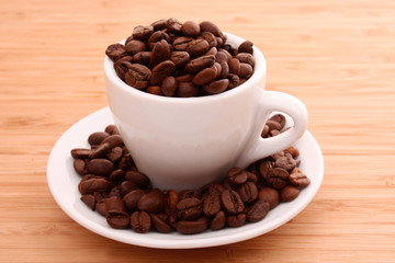 Fototapeta premium Small white cup of coffee with coffee grain on grain background