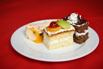 Fototapeta na wymiar тарелка с пирожными на красном фоне