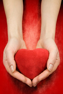 hands with heart on red grunge background