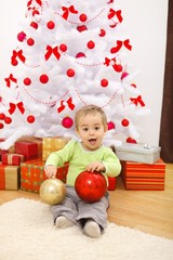 Fototapeta na wymiar Happy little boy with big Christmas ornaments