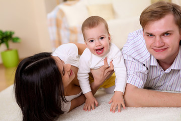 young family at home playing with a baby