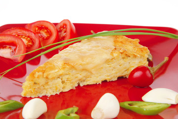 vegetable casserole piece over red plate