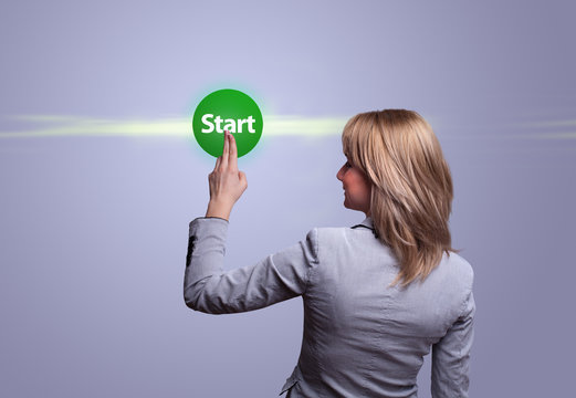 woman hand pressing green START button