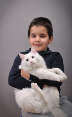 Cute boy with his white cat image vignetted.