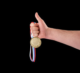 Fototapeta na wymiar Gold medal in hand isolated on black