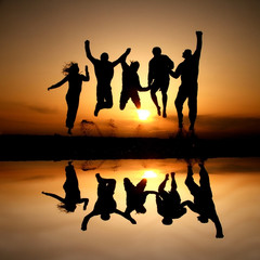 silhouette of friends jumping on beach in sunset - 29359822