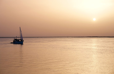 Fototapeta premium Recreation boat at sunset, in Ria Formosa, natural conservation
