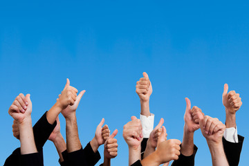 Multiracial Thumbs Up Against Blue Sky