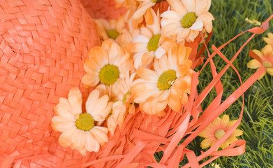 chapeau de paille et fleurs oranges