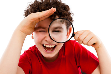 Boy looking through magnifying glass isolated on white