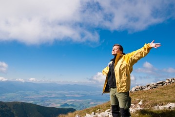 Woman enjoys sun in mountains on hiking