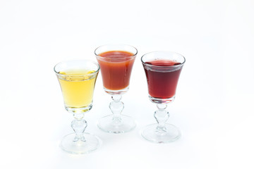 Three glass glasses of different juice