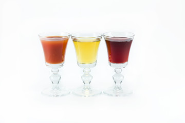 Three glass glasses of different juice