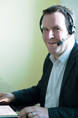 Closeup of a businessman with  tablet pc and headset