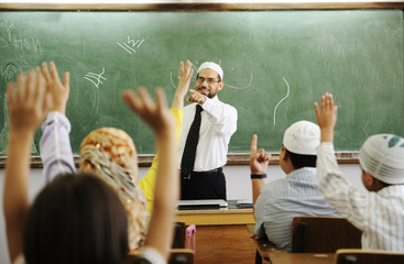 Teacher with children in classroom, boys and girls in school