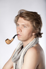 Attractive young man smoking pipe