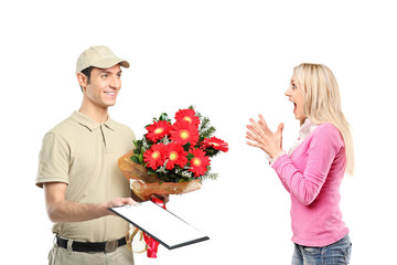 Delivery boy holding a bunch of flowers and surprised woman