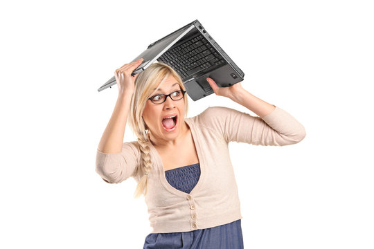 A scared female covering her head with a laptop
