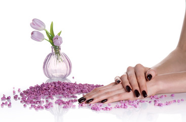 Dark mancure, spa stones and lilac vase with tulips