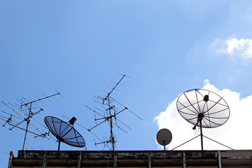 Satellite Dish and radio antenna on top of building