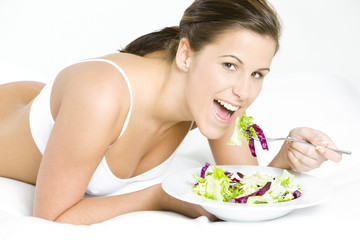 portrait of lying down woman eating salad