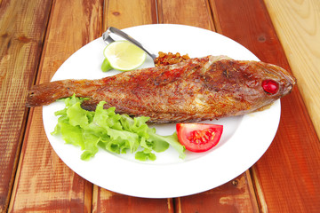 main portion of two grilled fish served on plate