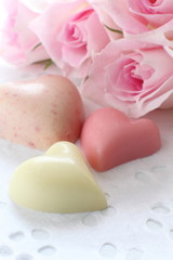 Obraz na płótnie Canvas Pink roses and heart shaped chocolate