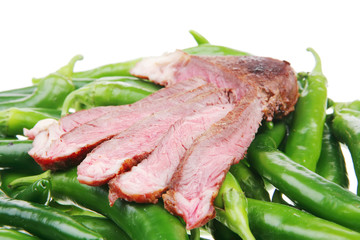 meat steak sliced over green hot chili peppers