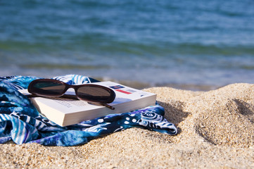 Fototapeta na wymiar Książka i okulary na plaży