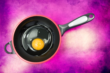 egg on the frying pan. isolated on purple background