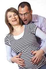 Fototapeta premium Happy young man and his pregnant wife isolated on white