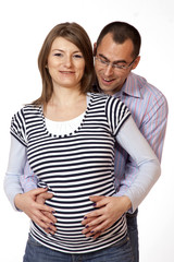 Happy young man and his pregnant wife isolated on white