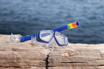 blue diving goggles with snorkel near sea