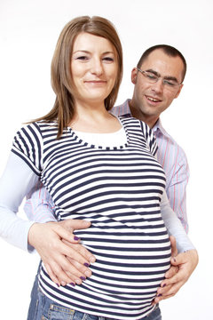 Happy young man and his pregnant wife isolated on white