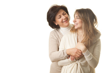 Mother and daughter hugging and smiling against white background